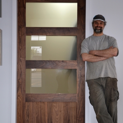 Optez pour l'élégance d'une porte coulissante en noyer noir conçue par l'ébénisterie québécoise Le Temps des Cigales, spécialiste du bois et de la cuisine à Québec.